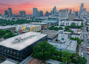 Thumbnail 13 of 16 - A cityscape with a large building in the foreground and several other buildings in the background.