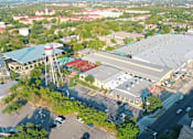 Thumbnail 15 of 19 - An aerial view of a large building with a parking lot in front of it.