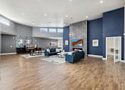 Thumbnail 2 of 23 - A living room with a blue couch and a wooden floor.