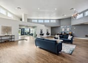 Thumbnail 3 of 23 - A spacious living room with a dark blue sofa and wooden flooring.