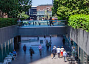 Thumbnail 23 of 27 - A group of people are walking through a pedestrian area.