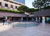 Thumbnail 20 of 27 - A shopping mall with a fenced off area in the middle.