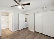 Thumbnail 12 of 23 - A room with a ceiling fan and white doors.