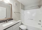 Thumbnail 15 of 23 - A white toilet sits next to a sink in a bathroom.