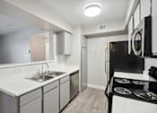 Thumbnail 7 of 23 - A modern kitchen with a black stove top oven.