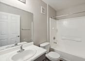Thumbnail 14 of 23 - A white bathroom with a toilet, sink, and bathtub.