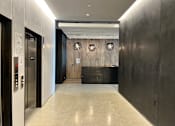 Thumbnail 8 of 9 - A hallway with a black wall and a white door.