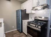 Thumbnail 1 of 34 - A kitchen with a stove, oven, and refrigerator.