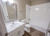 Thumbnail 33 of 34 - A white bathroom with a sink, toilet, and bathtub.