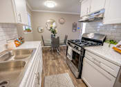 Thumbnail 15 of 34 - A kitchen with a stove top oven and a sink.