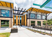 Thumbnail 11 of 19 - A modern building with a wooden facade and glass doors.