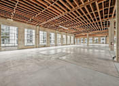 Thumbnail 17 of 17 - A large empty room with wooden ceiling and concrete floor.