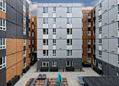 Thumbnail 22 of 38 - A modern apartment complex with a courtyard in the middle.