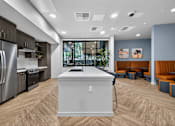 Thumbnail 21 of 38 - A modern kitchen with a large island in the middle.