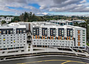Thumbnail 34 of 38 - A large, modern building with a curved driveway in front.
