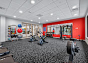 Thumbnail 1 of 38 - A gym with a variety of equipment including weights, a treadmill, and a stationary bike.