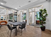Thumbnail 2 of 2 - A conference room with a table, chairs, and a potted plant.
