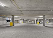 Thumbnail 12 of 38 - A large, empty parking garage with concrete pillars and floors.