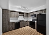 Thumbnail 30 of 38 - A modern kitchen with dark wood cabinets and black appliances.