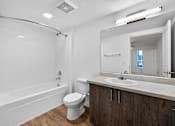 Thumbnail 29 of 38 - A white bathroom with a toilet, sink, and bathtub.
