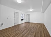 Thumbnail 13 of 38 - A room with wooden flooring and white walls.
