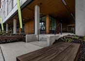 Thumbnail 37 of 38 - A modern building with a wooden bench in front of it.