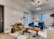 Thumbnail 15 of 51 - A living room with a blue couch and a yellow chair.