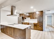 Thumbnail 25 of 51 - A modern kitchen with wooden cabinets and a white countertop.