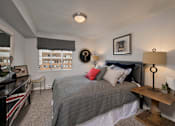 Thumbnail 24 of 51 - A bedroom with a bed, a desk, and a chair.