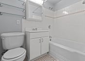 Thumbnail 48 of 51 - A white toilet sits next to a sink in a bathroom.