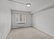 Thumbnail 42 of 51 - A room with a window and a carpeted floor.