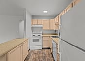 Thumbnail 31 of 51 - A kitchen with wooden cabinets and a white stove top oven.