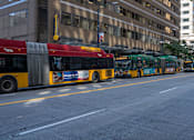 Thumbnail 51 of 51 - A red and yellow bus is parked on the side of a street.