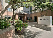 Thumbnail 49 of 51 - The Mill at First Hill is a modern building with a large entrance and a sign on the front.