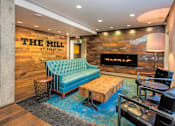 Thumbnail 6 of 51 - A blue sofa sits in front of a stone wall with a fireplace.