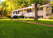 Thumbnail 1 of 8 - A white house with a green lawn in front of it.