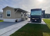Thumbnail 5 of 8 - A black bus is parked in front of a house.