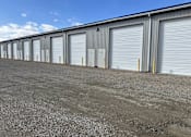 Thumbnail 6 of 13 - A long row of storage units with closed grey doors.