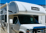 Thumbnail 9 of 13 - A Coleman camper is parked on a sunny day.