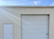 Thumbnail 6 of 10 - A large white garage door is closed.