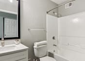 Thumbnail 9 of 33 - A white bathroom with a toilet, sink, and bathtub.