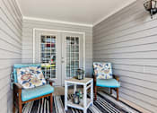 Thumbnail 5 of 33 - A porch with two chairs and a table.
