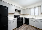 Thumbnail 26 of 31 - A kitchen with black appliances and white cabinets.