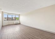 Thumbnail 9 of 22 - Bright Irvine Park Towers apartment living room with large windows and wood-look flooring