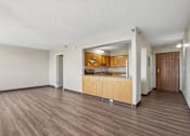 Thumbnail 11 of 22 - Irvine Park Towers apartment living area with open kitchen, breakfast bar and wood-look flooring
