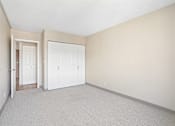 Thumbnail 18 of 22 - Irvine Park Towers apartment bedroom with carpet, double closet doors and neutral walls
