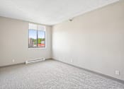 Thumbnail 19 of 22 - Bright Irvine Park Towers apartment bedroom with large window and carpeted flooring