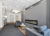 Thumbnail 5 of 22 - Resident lounge with seating and fireplace at Irvine Park Towers
