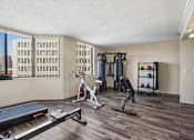 Thumbnail 7 of 22 - Irvine Park Towers fitness center with strength equipment, stationary bike and city views