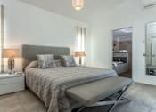 Thumbnail 2 of 7 - A bedroom with a bed, nightstands, and a chair.